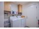 Bright laundry room includes washer, dryer, storage cabinets, and a convenient utility shelf at 2821 White Peaks Ave, North Las Vegas, NV 89081