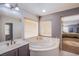 Relaxing main bathroom featuring a corner soaking tub and separate vanity, with natural light at 2821 White Peaks Ave, North Las Vegas, NV 89081