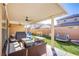 Relaxing covered patio area with comfortable seating and an outdoor ceiling fan at 2821 White Peaks Ave, North Las Vegas, NV 89081