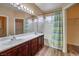 Bathroom with double vanity, tub, and wood-look floors at 3241 Rainmaker St, Las Vegas, NV 89129