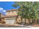 Two-story house with a white garage door and landscaping at 3241 Rainmaker St, Las Vegas, NV 89129