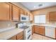 Bright kitchen features white appliances and wood cabinets at 3241 Rainmaker St, Las Vegas, NV 89129