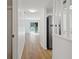 Hallway with light wood flooring leads to a light filled room and stainless steel appliances at 3823 S Maryland Pkwy # C3, Las Vegas, NV 89119