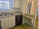 Kitchen featuring stainless steel dishwasher, white cabinets, and tile counter with a breakfast bar pass-through at 3823 S Maryland Pkwy # C3, Las Vegas, NV 89119