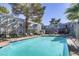 Community pool surrounded by lounge furniture, mature shade trees and greenery, and a security fence at 3823 S Maryland Pkwy # C3, Las Vegas, NV 89119