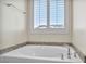 Relaxing bathtub with granite surround and large window with shutters at 4165 Kerberos Ave, North Las Vegas, NV 89084