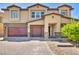 Two-story house with a red door and attached two-car garage, stone accents and landscaping at 4165 Kerberos Ave, North Las Vegas, NV 89084