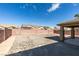 View of the spacious backyard with rock landscaping and a covered patio area at 5582 Little Lake Ave, Las Vegas, NV 89122