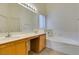 Bright bathroom features a double sink vanity with wood cabinets and a large soaking tub at 5582 Little Lake Ave, Las Vegas, NV 89122