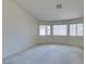 Empty bedroom featuring neutral carpet, three windows with coverings, and light walls at 5582 Little Lake Ave, Las Vegas, NV 89122