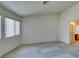 Neutral carpeted bedroom with an ensuite bathroom and a large window for natural light at 5582 Little Lake Ave, Las Vegas, NV 89122