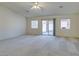 Spacious living room with neutral carpet, ceiling fan, and sliding door to backyard at 5582 Little Lake Ave, Las Vegas, NV 89122