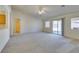 Large, open living room with neutral carpet, ceiling fan, and backyard access at 5582 Little Lake Ave, Las Vegas, NV 89122