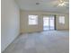 Spacious living room features carpet, a ceiling fan, large windows, and a sliding glass door at 5582 Little Lake Ave, Las Vegas, NV 89122