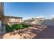 Spacious backyard featuring gravel landscaping, a covered patio, and a patch of green grass at 601 Sierra Ln, Henderson, NV 89002