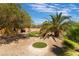 Landscaped backyard with putting green and palm trees at 6165 Smarty Jones Ave, Las Vegas, NV 89131