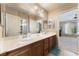 Double vanity bathroom with large mirror and view into bedroom at 6165 Smarty Jones Ave, Las Vegas, NV 89131