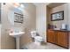 Powder room with pedestal sink and wooden cabinet at 6165 Smarty Jones Ave, Las Vegas, NV 89131