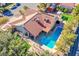 Aerial view of a backyard featuring a pool, red-tiled roof, and mature trees at 6185 N Conquistador St, Las Vegas, NV 89149