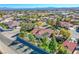 Aerial view of a home featuring a backyard pool, mature trees, and a red-tile roof in a desert landscape at 6185 N Conquistador St, Las Vegas, NV 89149