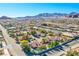 Expansive aerial view showcasing a neighborhood with mountain views and mature landscaping under a clear blue sky at 6185 N Conquistador St, Las Vegas, NV 89149