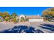 Single-story home with a three-car garage and palm trees at 6185 N Conquistador St, Las Vegas, NV 89149