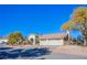 Single-story house with a three-car garage and desert landscaping at 6185 N Conquistador St, Las Vegas, NV 89149