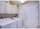 Bright laundry room with washer, dryer, and storage cabinets at 6185 N Conquistador St, Las Vegas, NV 89149