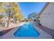 Long rectangular pool in backyard with surrounding landscaping and string lights at 6185 N Conquistador St, Las Vegas, NV 89149