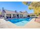 Large kidney-shaped pool in backyard with patio and house in background at 6185 N Conquistador St, Las Vegas, NV 89149