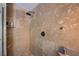 Large walk-in shower with beige stone tile and modern fixtures at 6185 N Conquistador St, Las Vegas, NV 89149