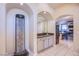 Elegant wet bar with stone waterfall feature and kitchen access at 6185 N Conquistador St, Las Vegas, NV 89149