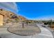 Landscaped backyard with a fountain and pathway, desert plants and mountain views at 7079 Mountridge Dr, Las Vegas, NV 89110