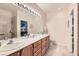 Elegant bathroom with dual sinks, a large mirror, and a walk-in shower at 7517 Lintwhite St, North Las Vegas, NV 89084