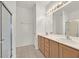 Bathroom with double vanity, shower, and light wood cabinets at 7568 Lily Trotter St, North Las Vegas, NV 89084