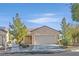 Single-story house with tan exterior, attached garage, and desert landscaping at 7568 Lily Trotter St, North Las Vegas, NV 89084