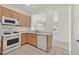 Open kitchen with light wood cabinets, white appliances, and view to dining area at 7568 Lily Trotter St, North Las Vegas, NV 89084