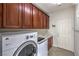 Laundry room with wooden cabinets and washer dryer at 7923 Sleeping Lily Dr, Las Vegas, NV 89178