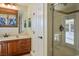 Bathroom vanity with wood cabinets, tile countertop, and glass door shower at 8365 Hauck St, Las Vegas, NV 89139