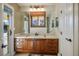 Bathroom vanity with wood cabinets, tile countertop, and a view to the pool at 8365 Hauck St, Las Vegas, NV 89139