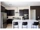 Modern kitchen with dark cabinetry, stainless steel appliances, and quartz countertops at 862 Silverton Springs St, Henderson, NV 89011