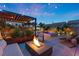 Outdoor living area with a fire pit, lounge seating, and a pool in the background at 8620 Grove Mill Ct, Las Vegas, NV 89139