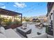 Inviting backyard with lounge area, pergola, modern fire pit, and a view of the lush greenery at 8620 Grove Mill Ct, Las Vegas, NV 89139