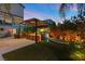 Lush backyard with a built-in kitchen, bar seating, a hammock, and green grass at 8620 Grove Mill Ct, Las Vegas, NV 89139