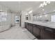 Elegant bathroom with double sinks, marble countertops, and herringbone tile floor at 8620 Grove Mill Ct, Las Vegas, NV 89139