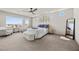 Bright bedroom featuring a ceiling fan, carpet floors, a large window with a scenic view, and comfortable seating at 8620 Grove Mill Ct, Las Vegas, NV 89139