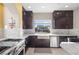 Modern kitchen featuring stainless steel appliances, dark cabinets, and white marble backsplash and countertops at 8620 Grove Mill Ct, Las Vegas, NV 89139