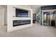 Open living space featuring a sleek fireplace, modern design, and access to an outdoor patio at 8620 Grove Mill Ct, Las Vegas, NV 89139