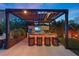 Stylish outdoor kitchen with a pergola, bar seating, and built-in appliances for alfresco entertaining at 8620 Grove Mill Ct, Las Vegas, NV 89139