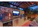 Covered outdoor kitchen with a grill, pizza oven, a built-in TV, and beautiful tile backsplash at 8620 Grove Mill Ct, Las Vegas, NV 89139